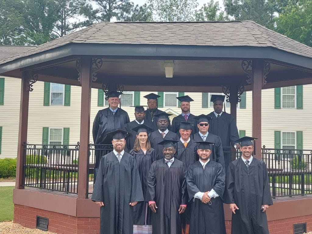 TROSA Spring 2022 Graduates standing outside on TROSA's grounds under a gazebo