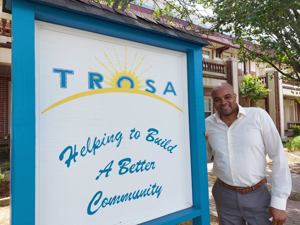 TROSA graduate Christopher stands outside TROSA graduate apartment housing