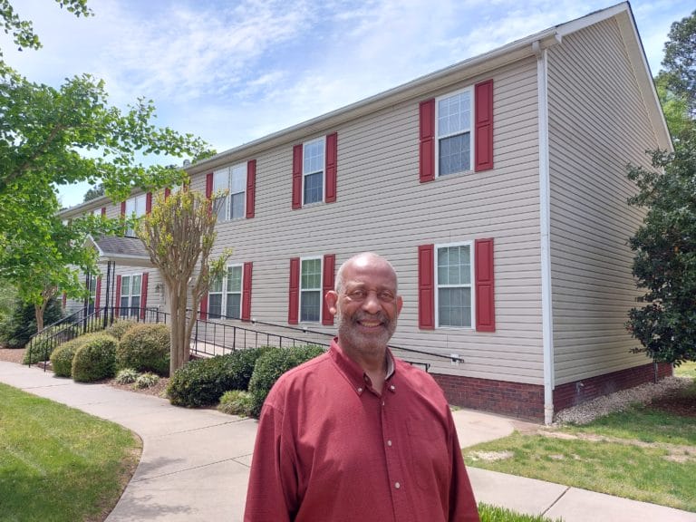 TROSA graduate Carl stands in front of a TROSA home on the Durham campus