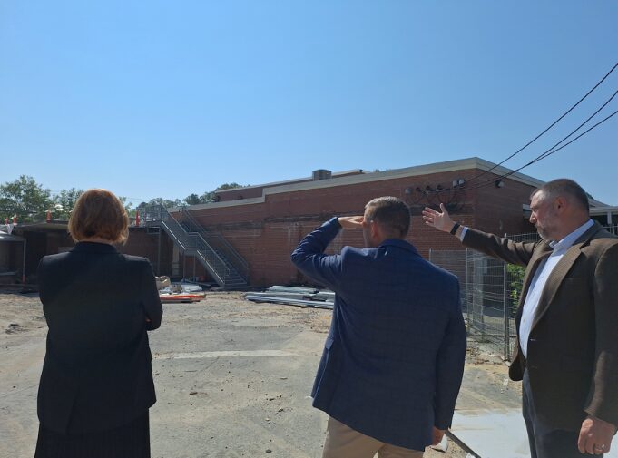 (from L to R): TROSA Chief Development Officer Morgan Edwards Whaley, Truist Triangle West Market President Jordan Clark. and TROSA President and CEO Keith Artin visit construction progress on McDonald Hall, standing outside at a construction site